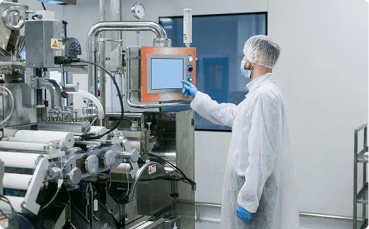 alt="Factory operator monitoring industrial equipment to ensure safety compliance"